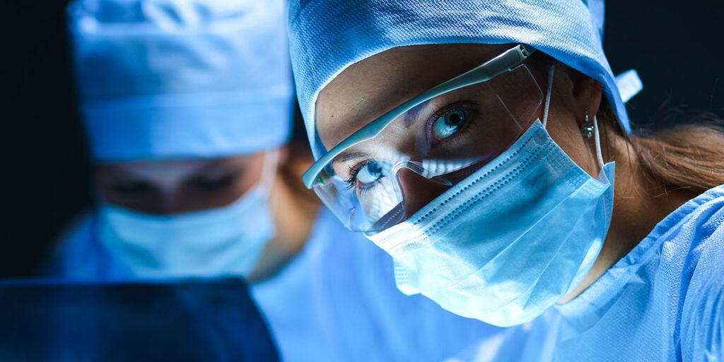 Nurses wearing blue surgical masks and blue scrubs